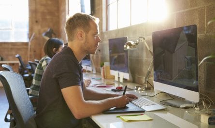 Designers Working At Desks In Modern Office