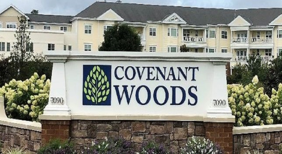 Covenant Woods sign and buildings in the background